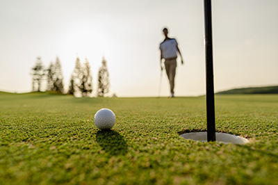 Golfer beim Putten auf dem Gr&uuml;n